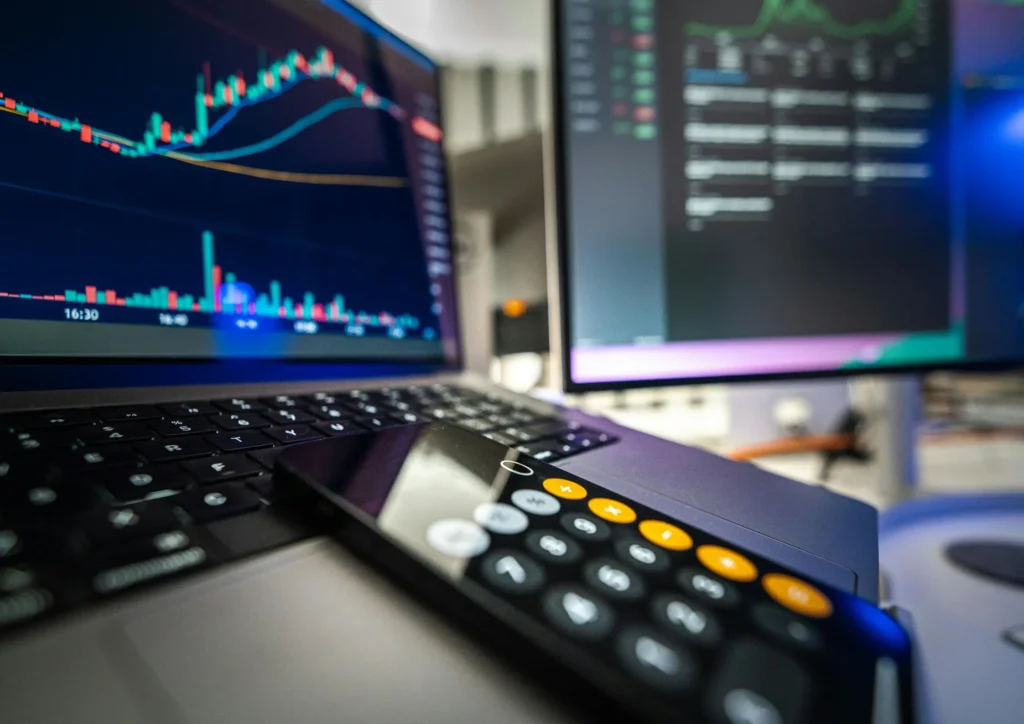 Close-up of a laptop displaying performance charts and trading-style analytics, symbolizing data signals and optimization in Meta’s AI-driven ad system.