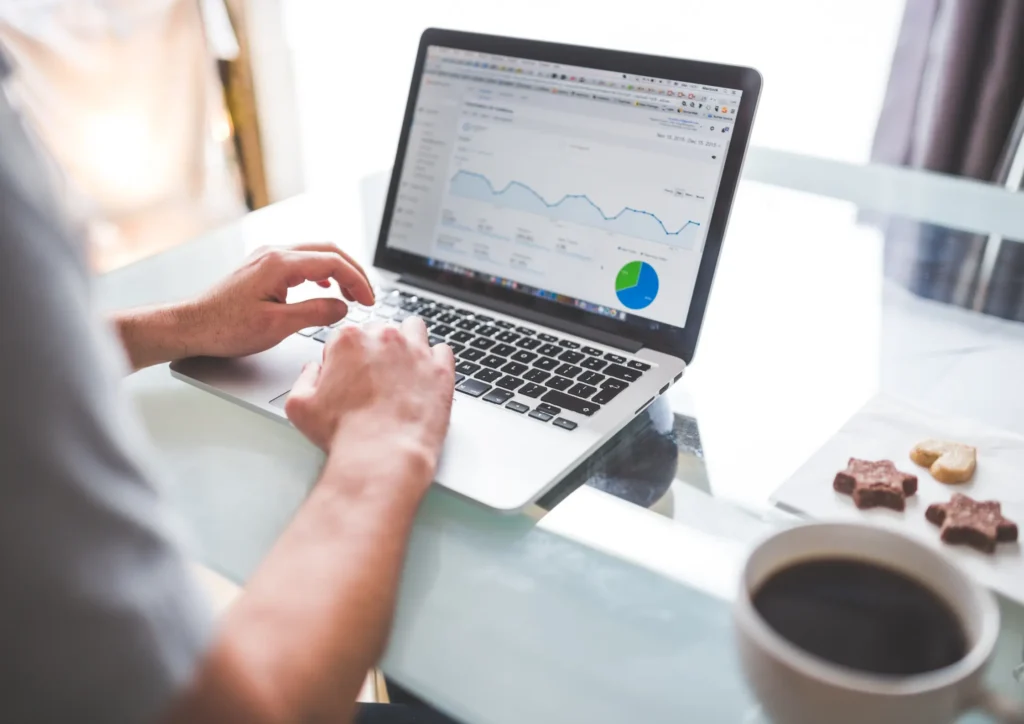 Person analyzing marketing analytics on a laptop, reviewing lead generation performance charts and metrics.