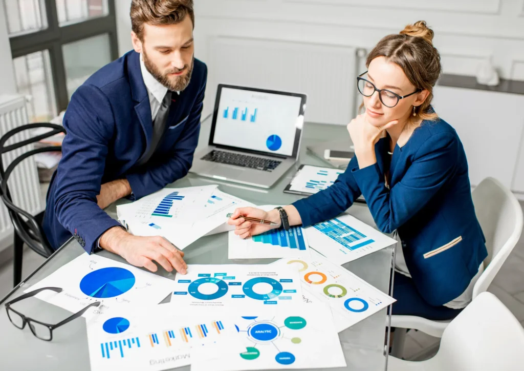 Two marketing professionals reviewing analytics charts and campaign data, representing strategic planning and performance optimization for Meta’s AI system.