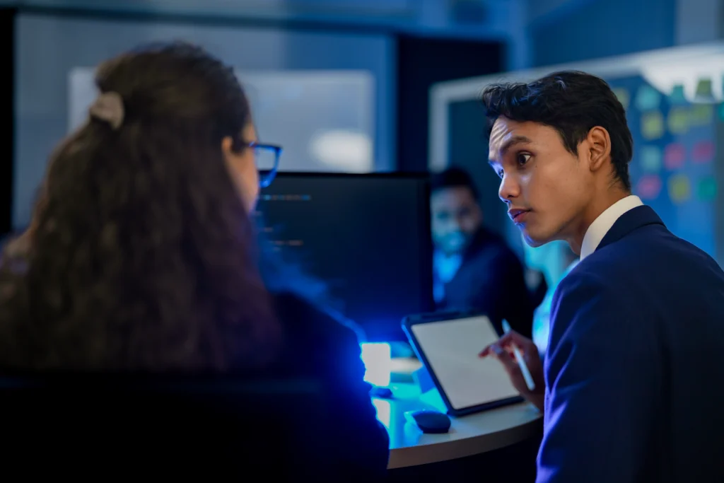 "Marketing analysts reviewing campaign data on tablets and monitors to diagnose why cost per lead is high."